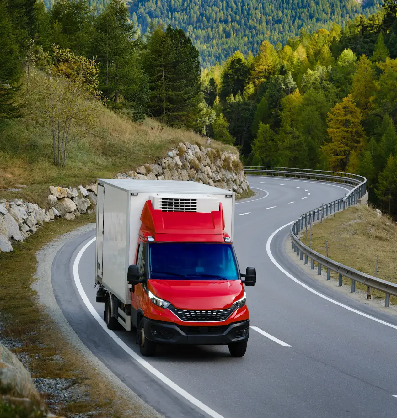 Red freight truck parked along a coastal highway
