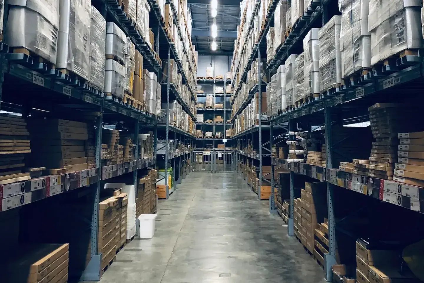 Pallet racking stacked with palletized goods along an aisle inside the Tulare Industrial Center warehouse available for lease